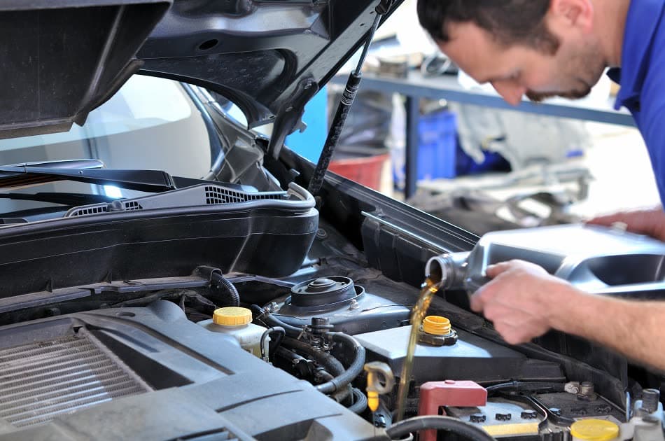 Technician draining oil during a routine service